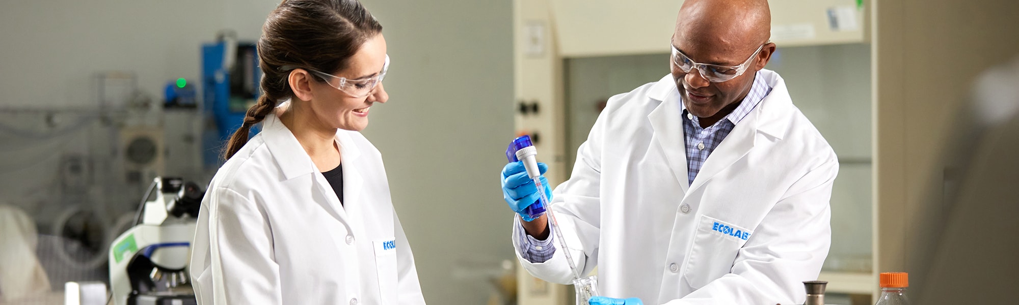 Two Ecolab experts in a lab filling test tubes